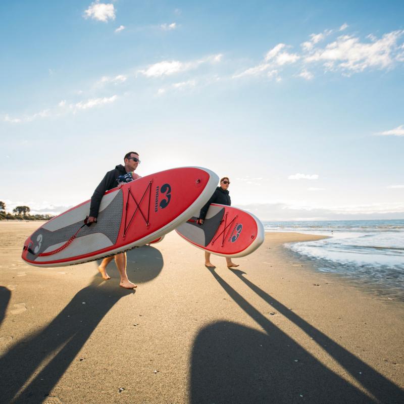 Walking to Water With Paddleboards at Tahunanui Beach