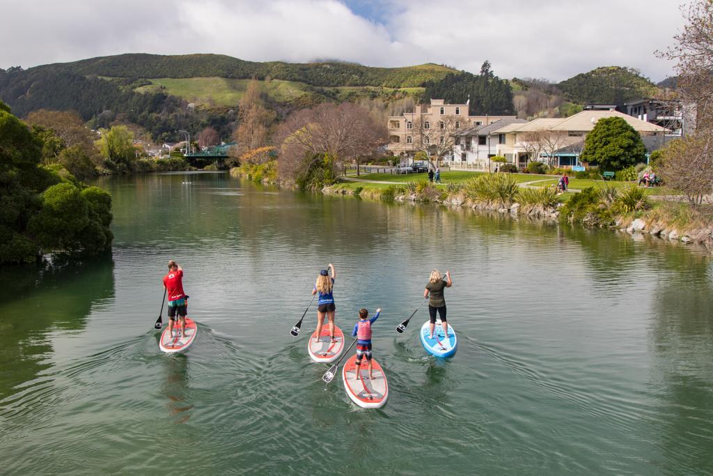 Paddling the Maitai River on standup paddleboards.