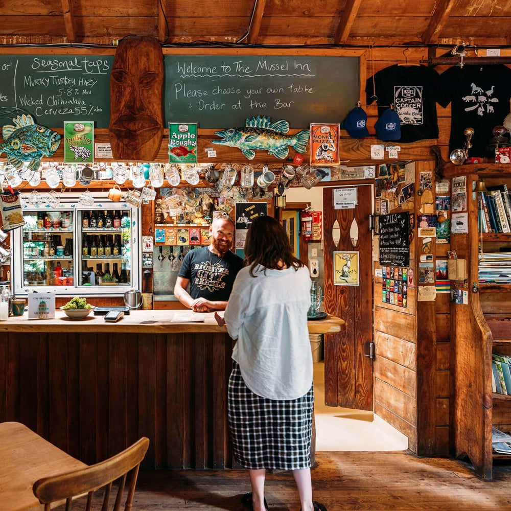 The Mussel Inn is a rustic, beloved spot known for its craft beers, live music, and laid-back vibe, nestled in the heart of Golden Bay.